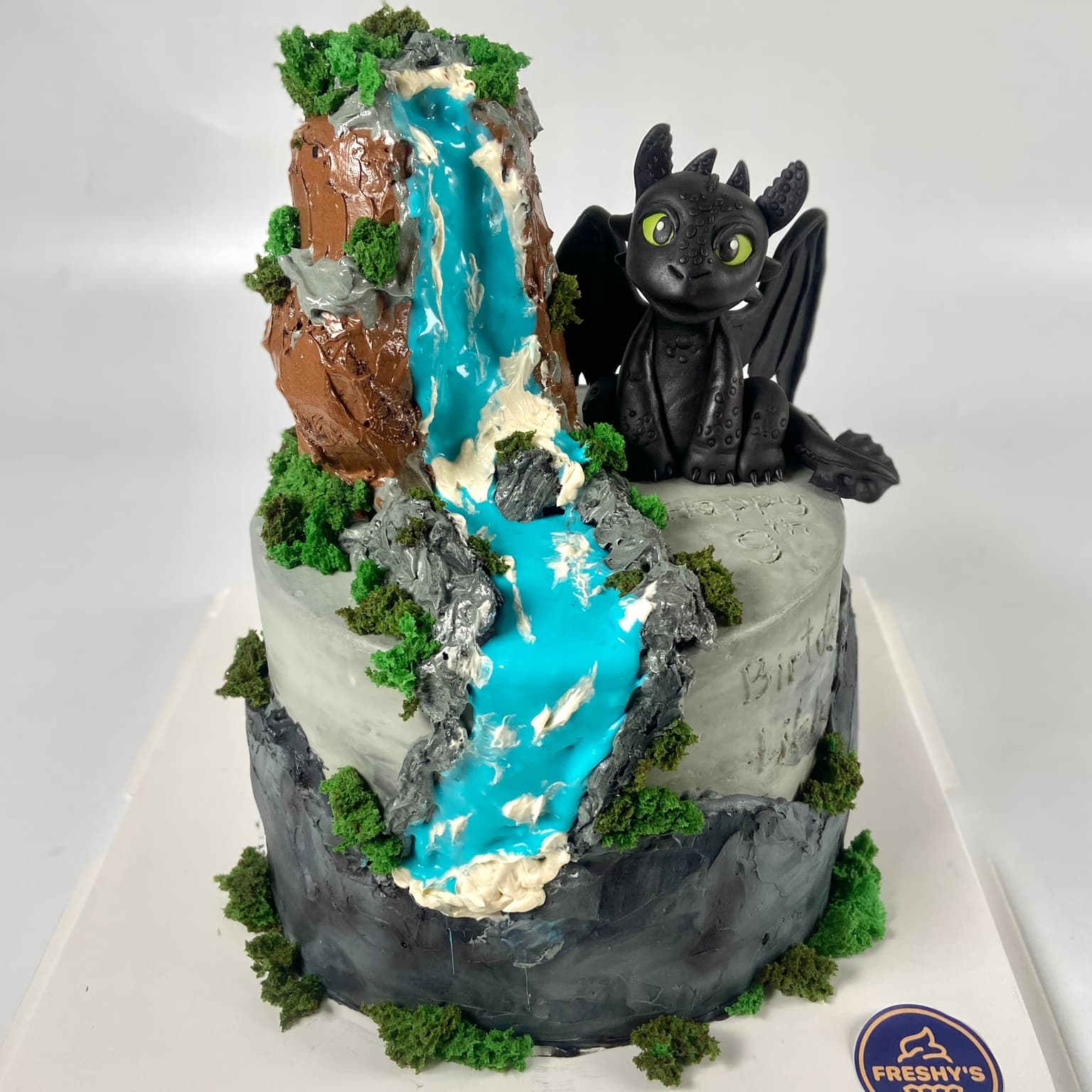 100% edible fondant sculpted Toothless Dragon beside watefall