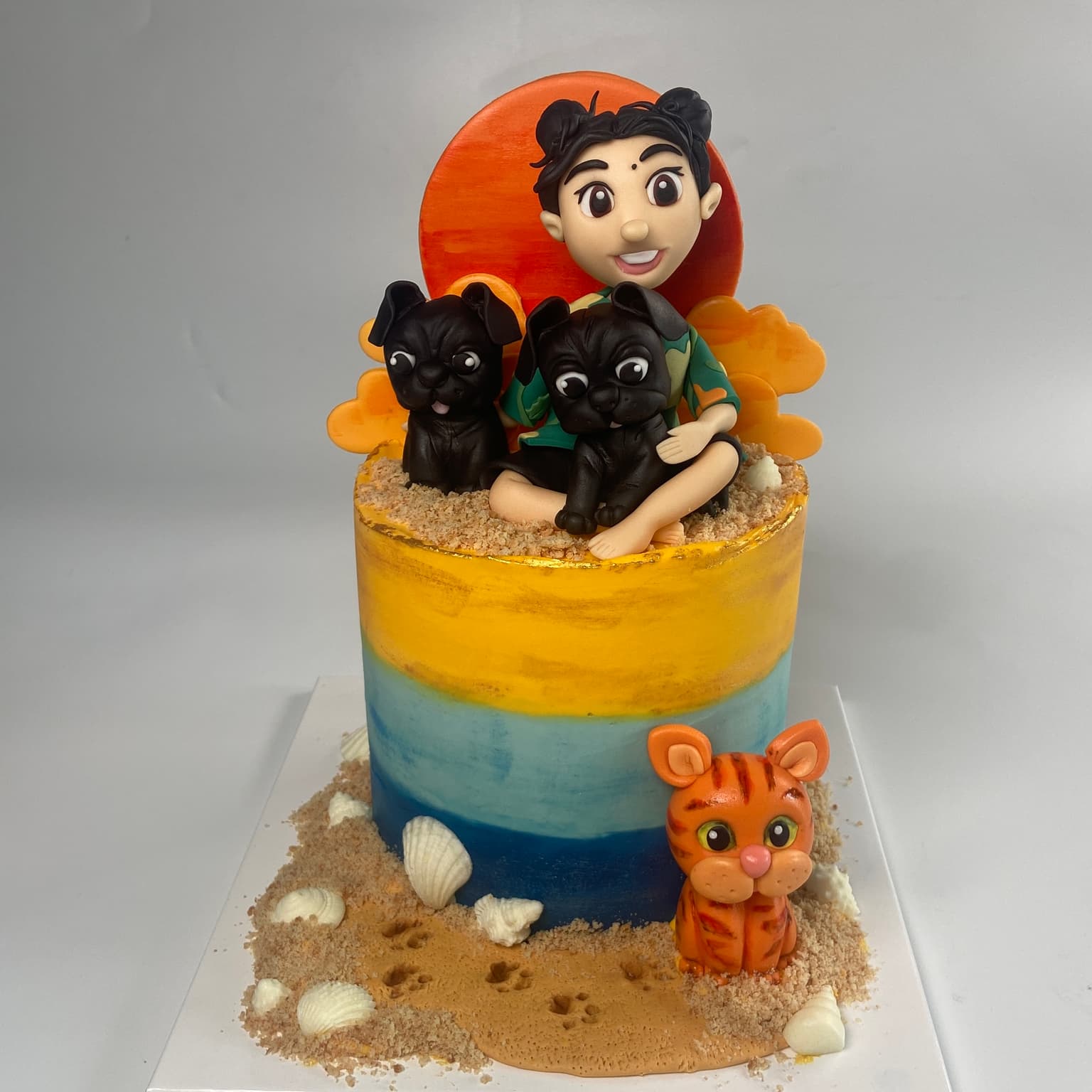 100% edible fondant sculpted girl sitting with pets on the beach ast sunset