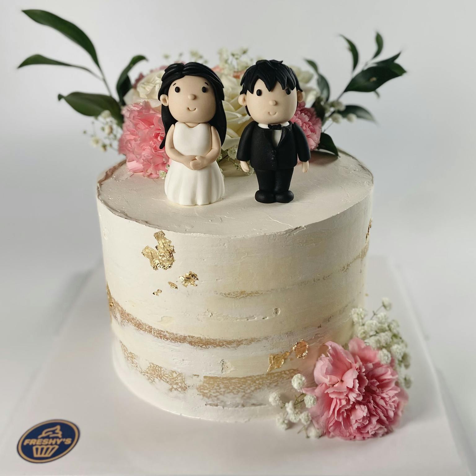 Fondant sculpted wedding cake with couple on top
