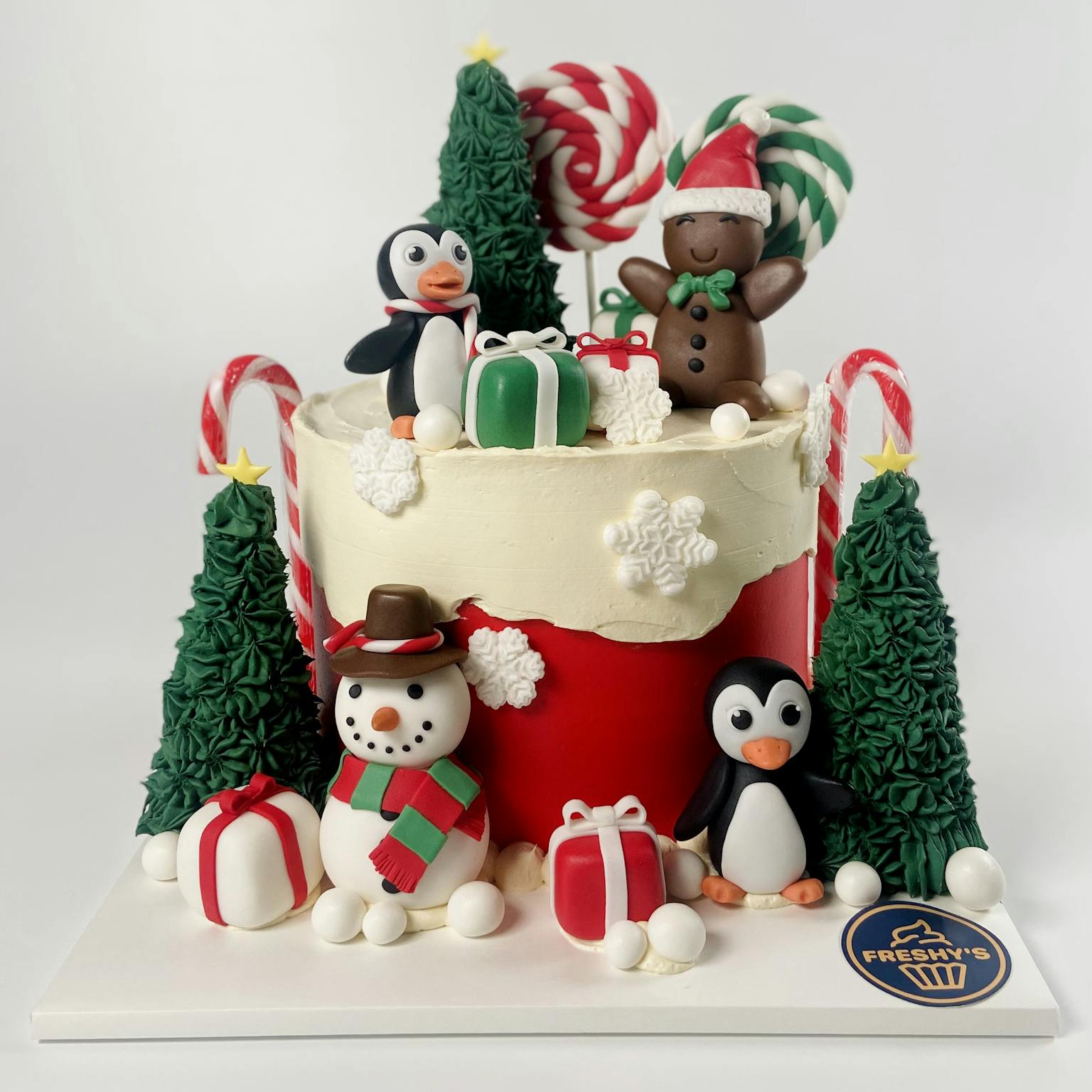 100% edible fondant sculpted Christmas themed cake with pengiuns and snowman