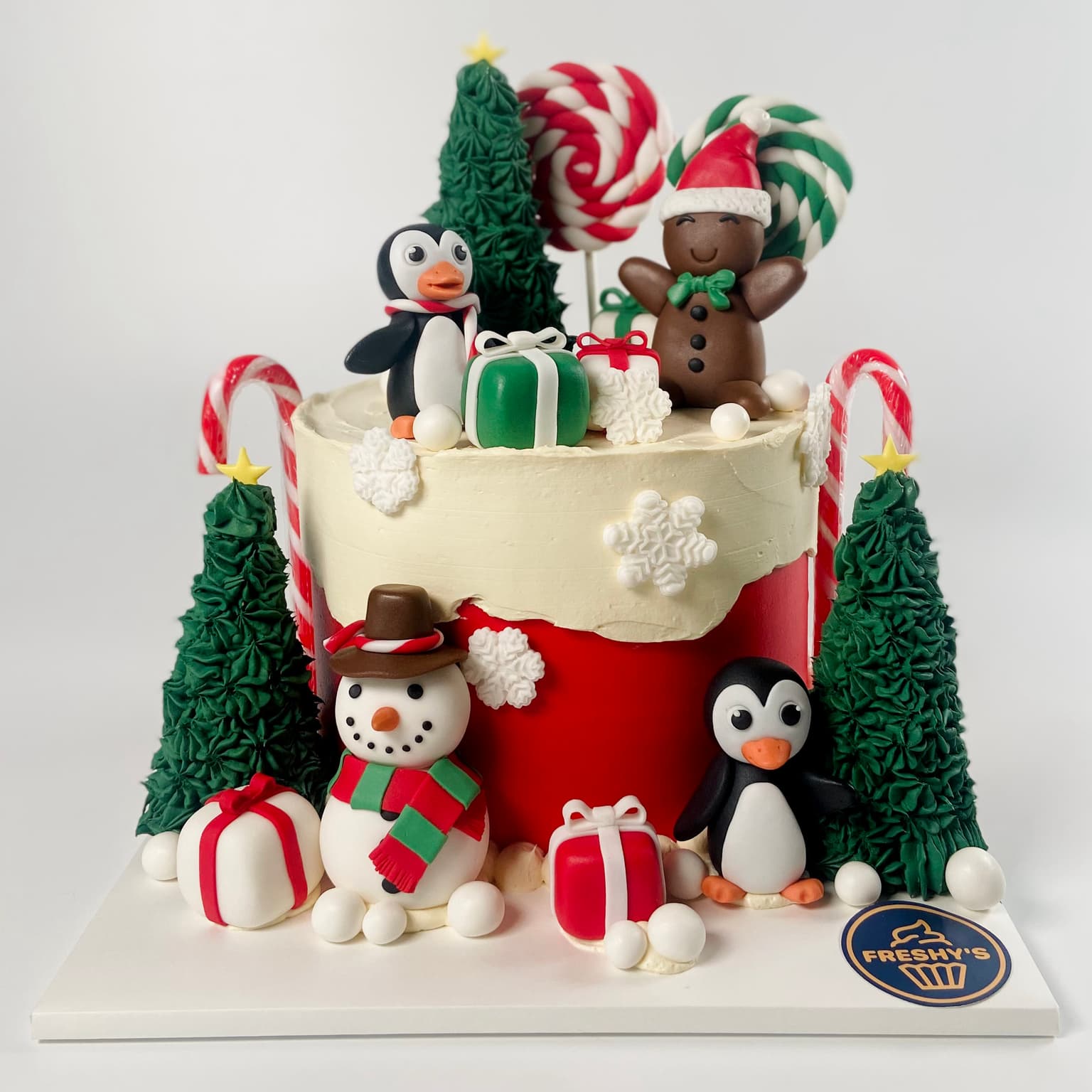 100% edible fondant sculpted Christmas themed cake with pengiuns and snowman